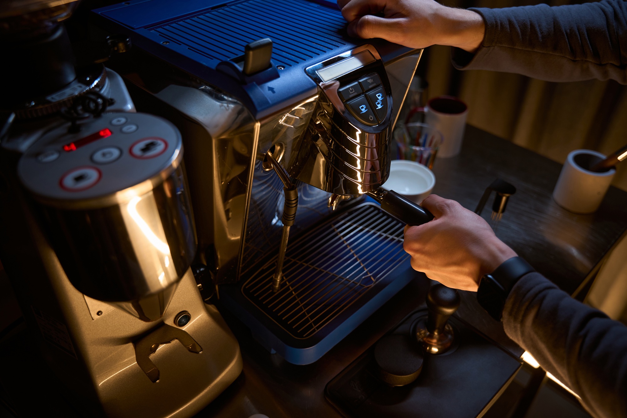 Barista with portafilter preparing aromatic drink in coffee machine
