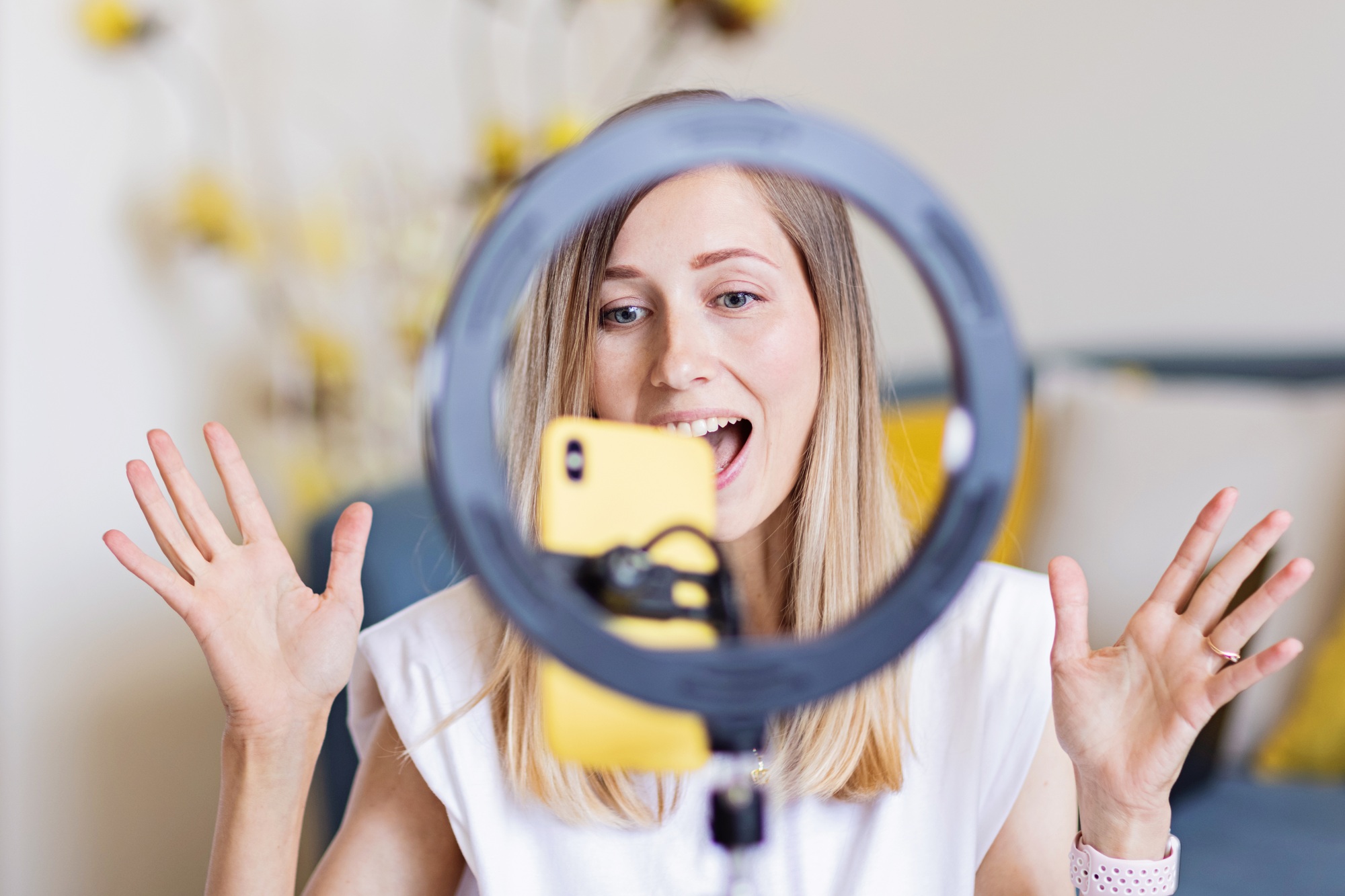 Happy caucasian woman using technology at home. Lifestyle Blogger communicating with followers